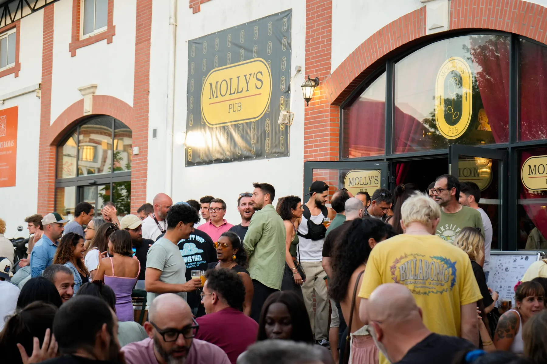 La foule rassemblée devant la façade du Molly’s Pub, sous son enseigne