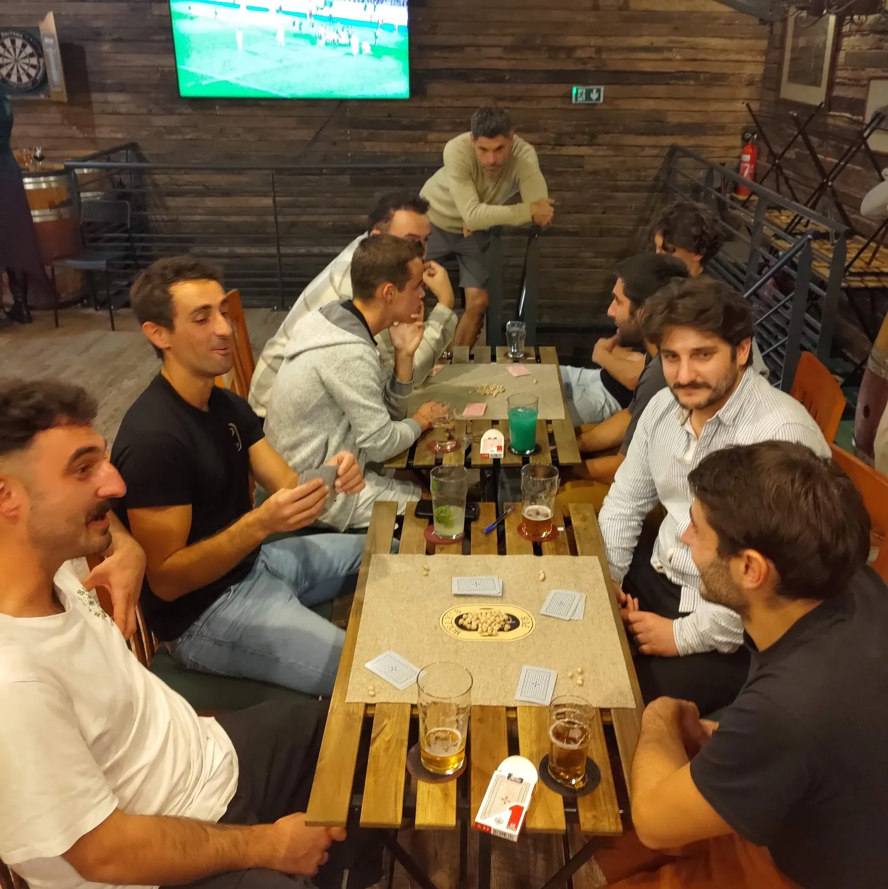 Mus partida bat Molly’s Pub-en, lau jokalari mahaian eta ikusleak inguruan