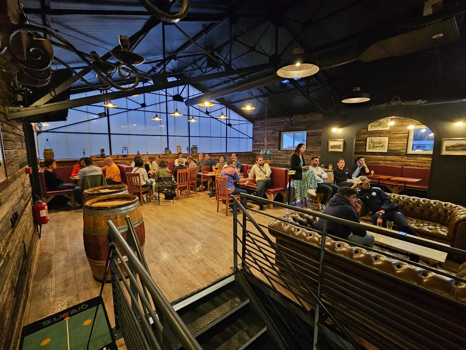 La mezzanine du Molly’s Pub vue d’en haut, canapés et tablées sous la verrière